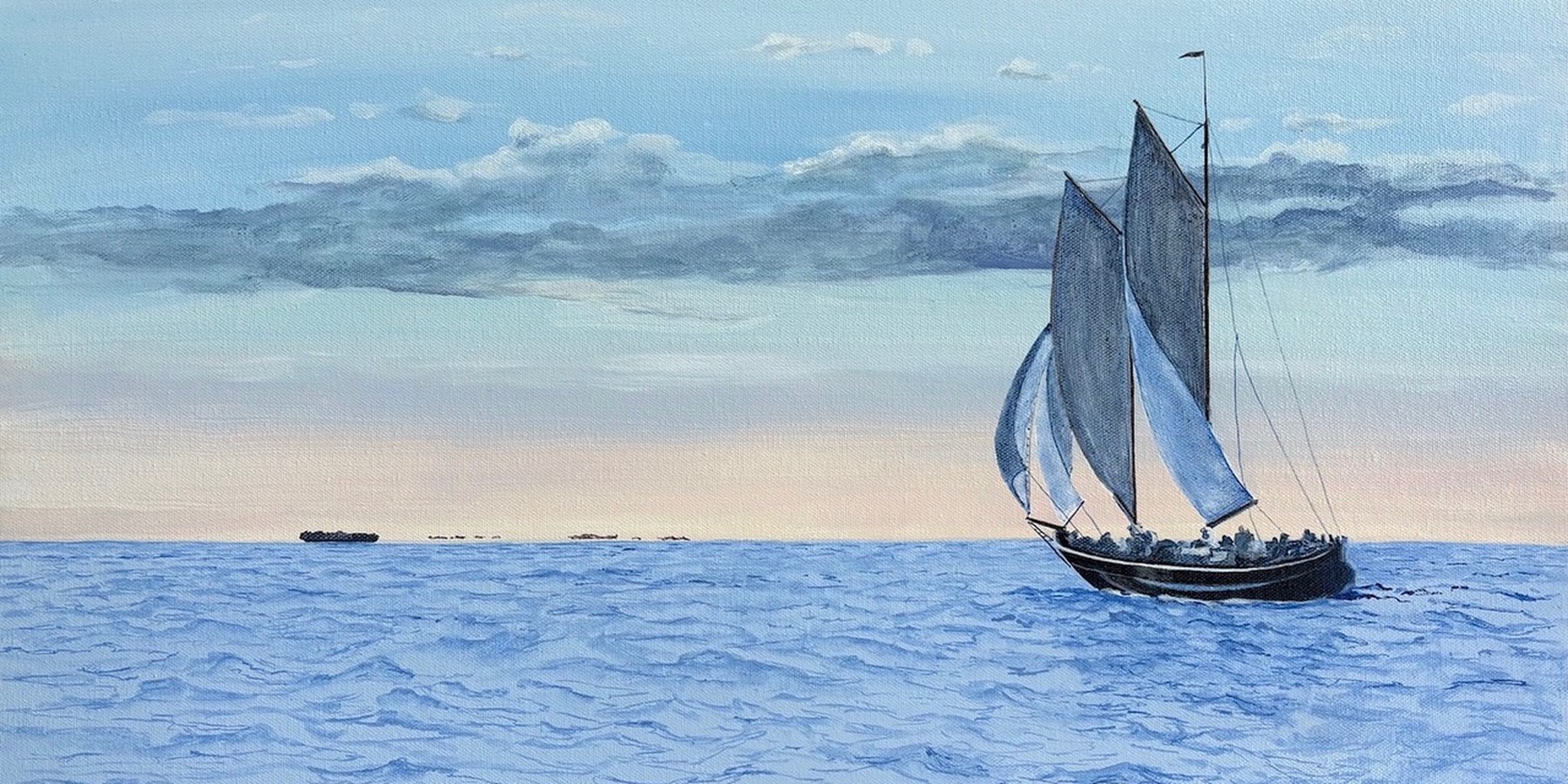 A schooner under full sail on calm open water beneath a long bank of cloud.