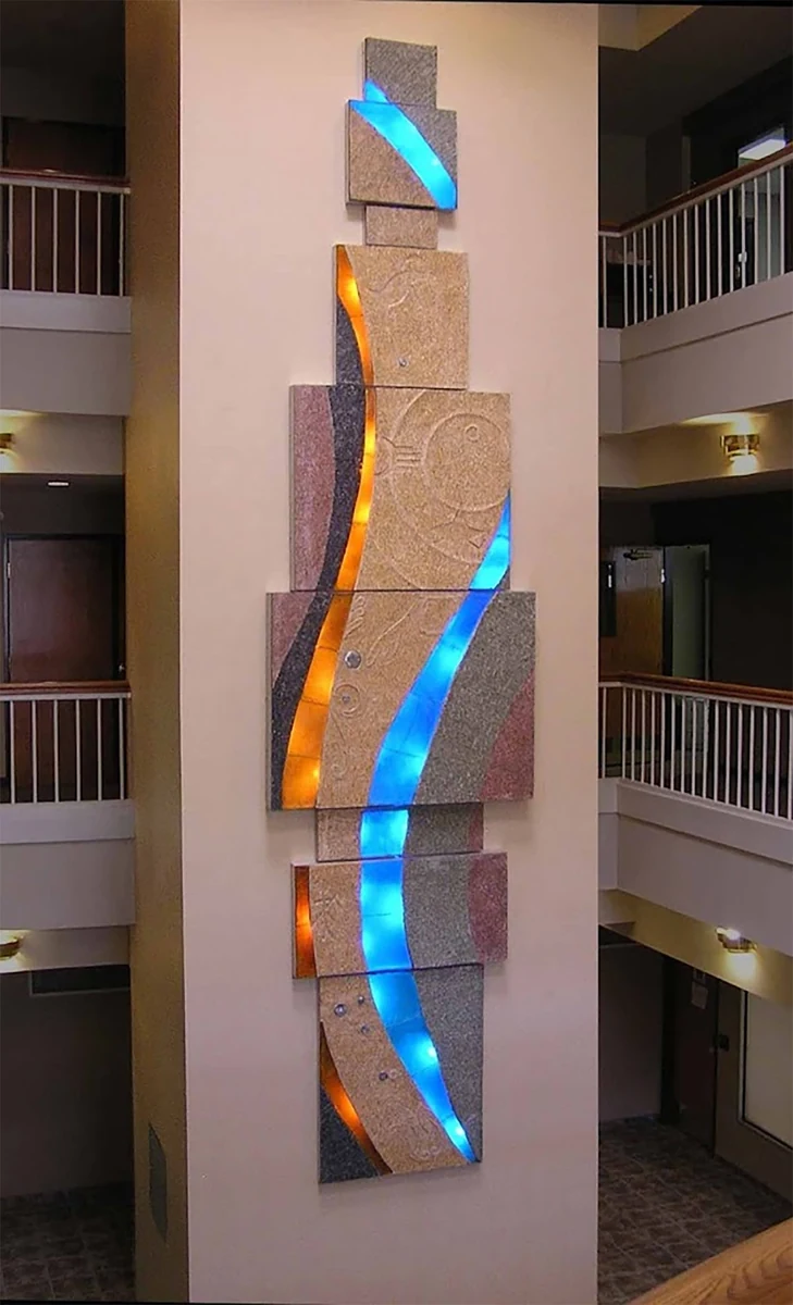 Pueblo, 2008, cast glass, LED lights, terrazzo composite and aluminum, 5.5 x 22.5 feet: a stacked vertical relief with lit blue and orange glass channels in a building atrium, Albu