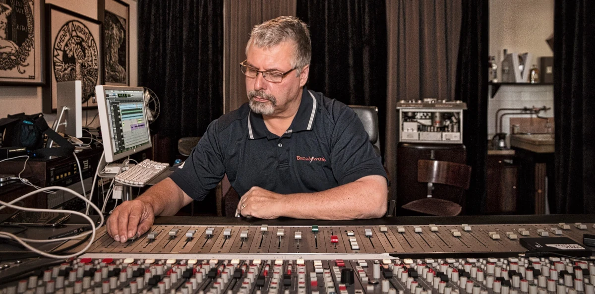 Jeff Dalton at the mixing console in a recording studio, hands on the faders