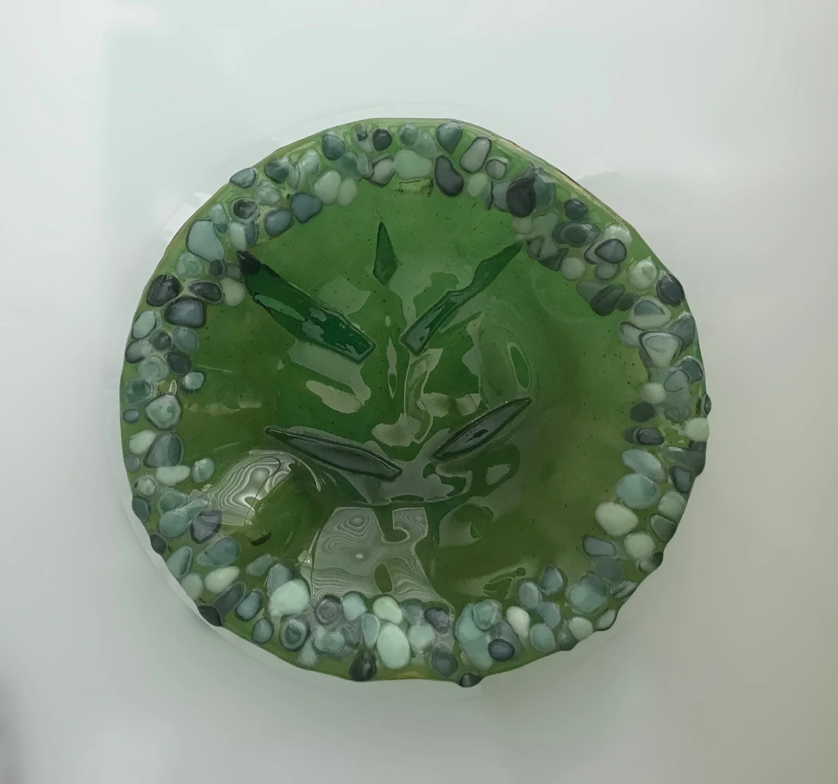 Cast fused glass bowl, green seagrape pattern with a pebbled rim, 9 inch round
