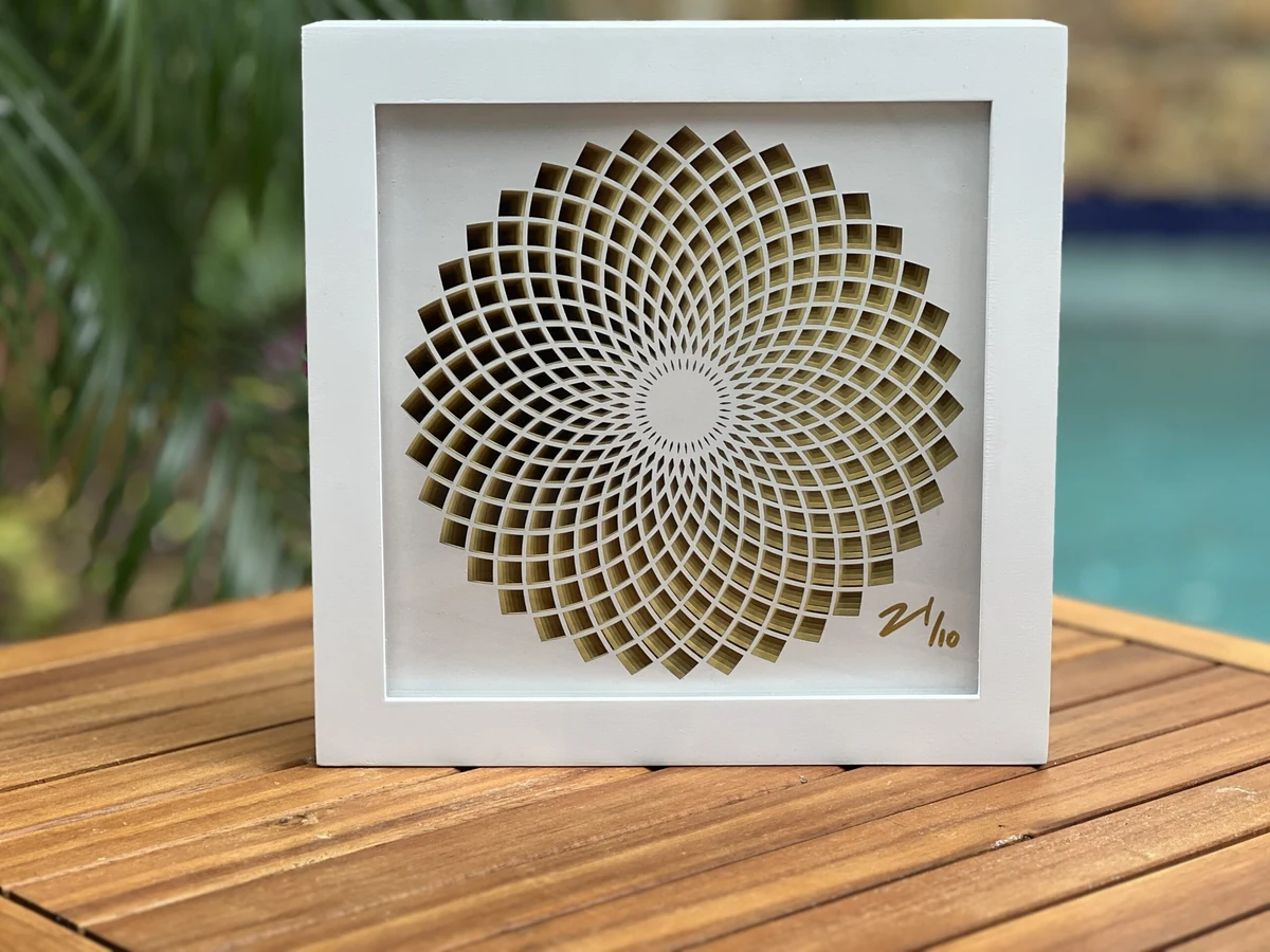 Key West Sunflower, a layered laser-cut geometric rosette in gold and cream, in a white shadow-box frame, signed and numbered